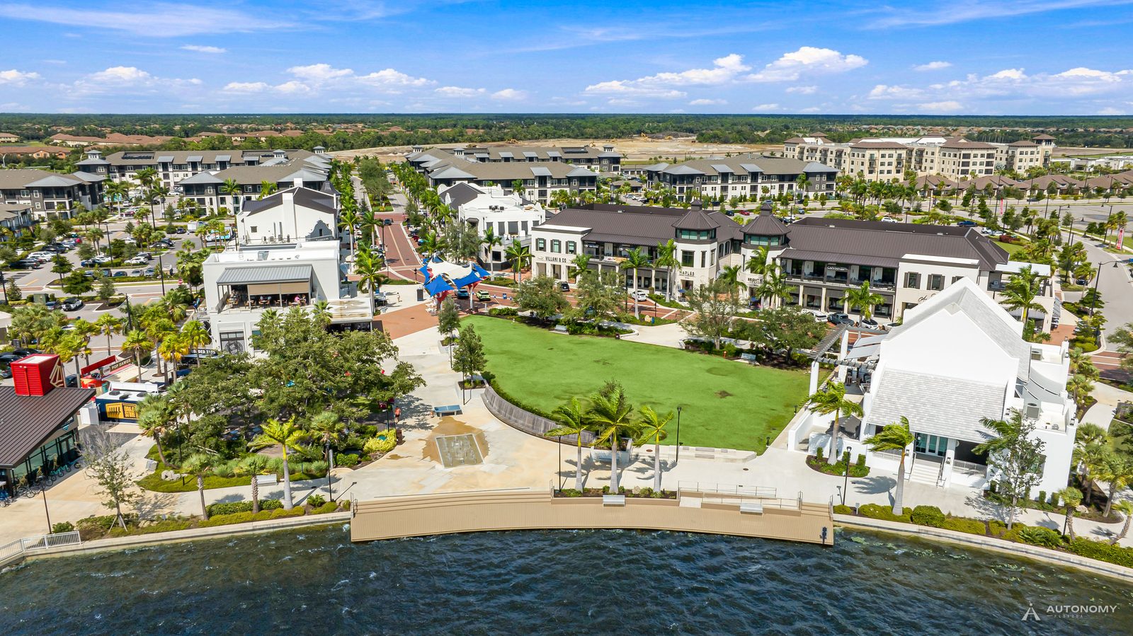 Daytime aerial of the Downtown Wellen lakefront lawn and buildings on the Grand Lake